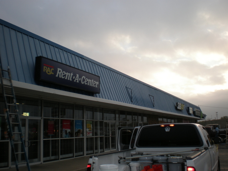 Exterior commercial painting of a retail storefront facade.