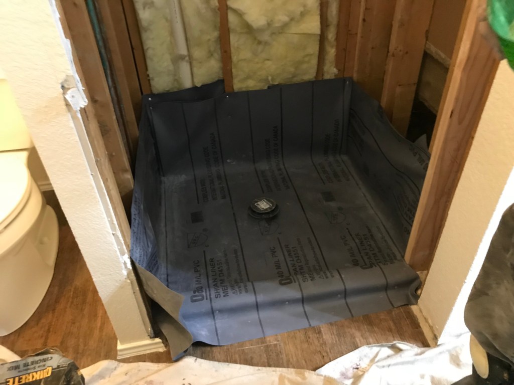 Installing our new shower pan for the shower remodel